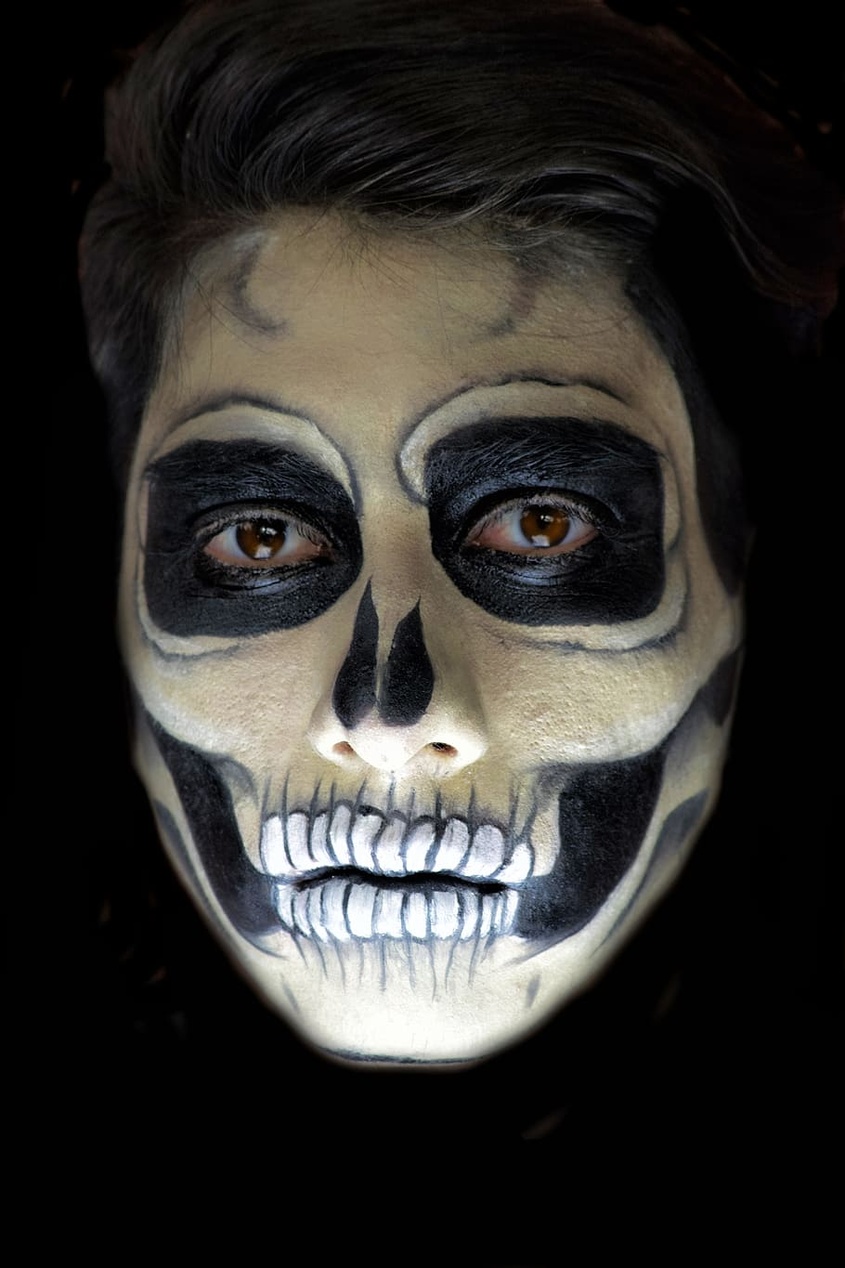 Ett leende barn med kreativ och färgglad ansiktsmålning som föreställer en fjäril.